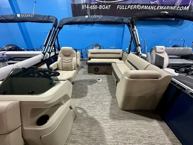Slide: The Image of 2024 Godfrey Sweetwater 2286 SFL GTP pontoon boat interior with beige seating and helm. - 8