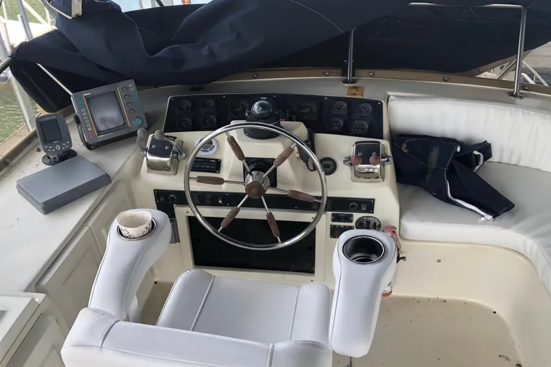 Slide: The Image of 1989 Bluewater Yachts 55' Coastal Cruiser helm with navigation equipment and white seating. - 31