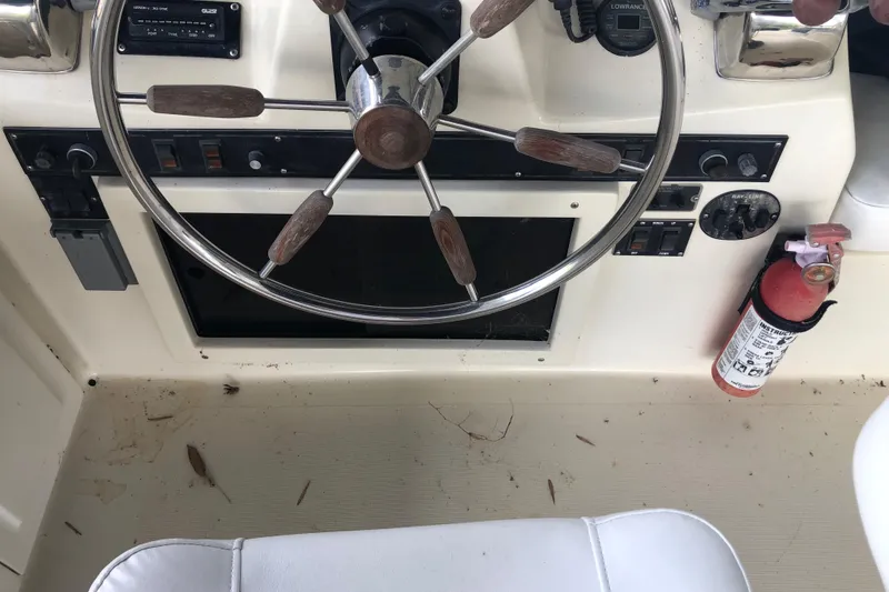 Slide: The Image of 1989 Bluewater Yachts 55' Coastal Cruiser helm with steering wheel and fire extinguisher. - 37