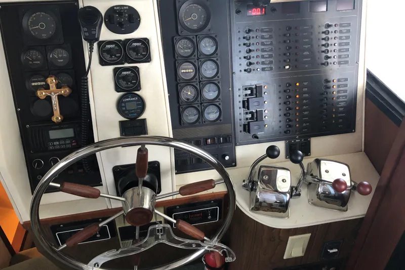 Slide: The Image of 1989 Bluewater Yachts 55' Coastal Cruiser helm with steering wheel and control panel. - 45