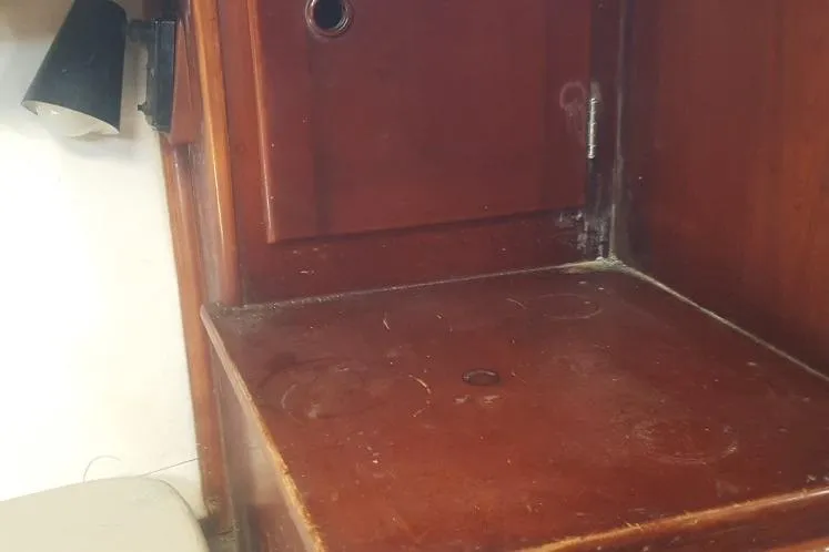 Slide: The Image of Wooden interior of 1973 Hodgdon DOLPHIN 47 boat, featuring a small cabinet and lamp. - 10