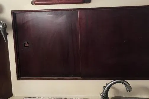 Slide: The Image of Interior of 1973 Hodgdon DOLPHIN 47 yacht with wooden cabinetry and metal faucet. - 26