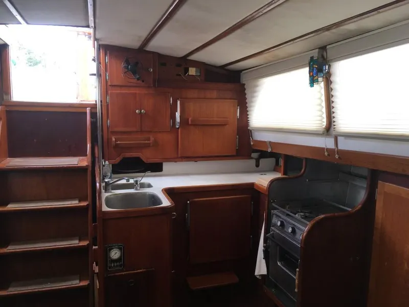 Slide: The Image of Interior of 1973 Hodgdon DOLPHIN 47 yacht with wooden cabinetry and compact kitchen. - 3