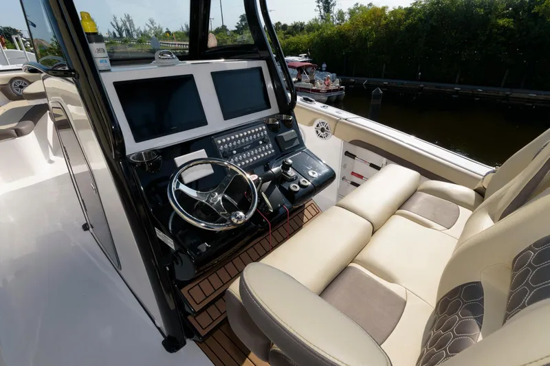 Slide: The Image of 2023 Tidewater 320 CC Adventure boat cockpit with dual screens and comfortable seating. - 12