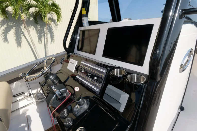 Slide: The Image of 2023 Tidewater 320 CC Adventure boat dashboard with dual screens and control panel. - 14