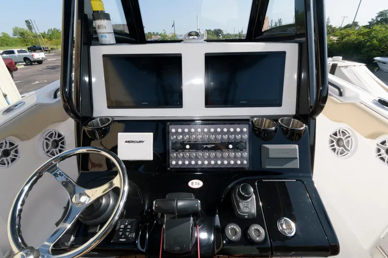 Slide: The Image of 2023 Tidewater 320 CC Adventure boat dashboard with dual screens and advanced controls. - 15
