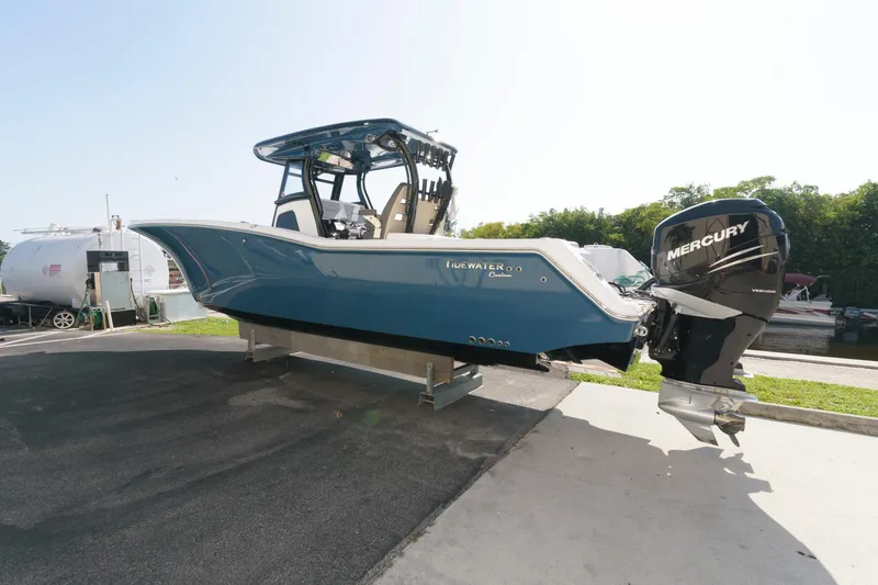 Slide: The Image of 2023 Tidewater 320 CC Adventure boat with Mercury outboard motor on a trailer. - 2