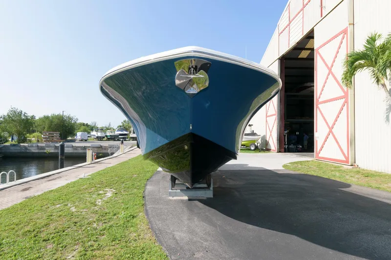 Slide: The Image of 2023 Tidewater 320 CC Adventure boat on display outside a marina. - 3