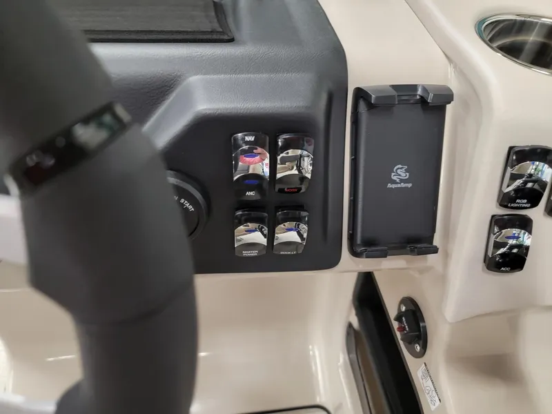 Slide: The Image of Control panel of 2024 Harris Cruiser 250 boat with switches and phone holder. - 12