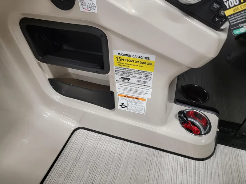 Slide: The Image of 2024 Harris Cruiser 250 boat dashboard with maximum capacity label and storage compartments. - 13