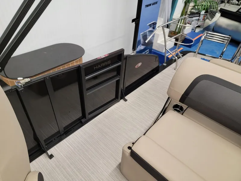 Slide: The Image of 2024 Harris Cruiser 250 boat interior with beige seating and black gate. - 15
