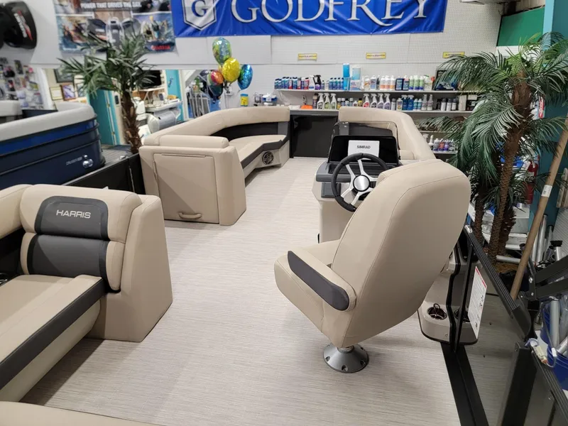 Slide: The Image of 2024 Harris Cruiser 250 pontoon boat interior with beige seating and steering console. - 20