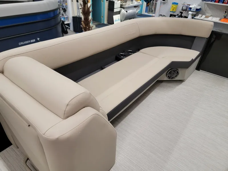 Slide: The Image of 2024 Harris Cruiser 250 boat interior with beige seating and cup holders. - 27