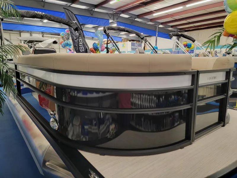 Slide: The Image of 2024 Harris Cruiser 250 pontoon boat on display in a showroom. - 3