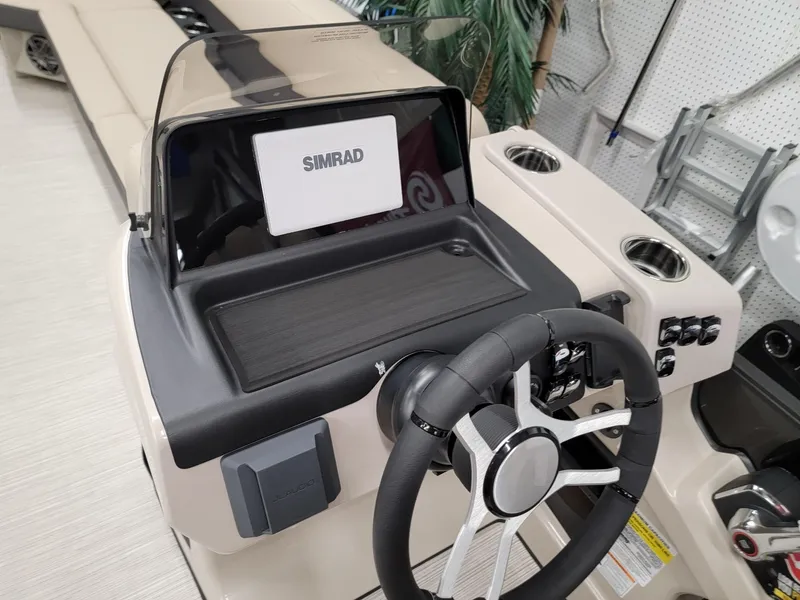Slide: The Image of 2024 Harris Cruiser 250 boat dashboard with Simrad display and steering wheel. - 9