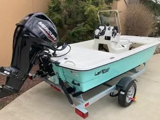 The Image of 2024 Mako Pro Skiff 13 CC boat with Mercury outboard motor on trailer. - 0