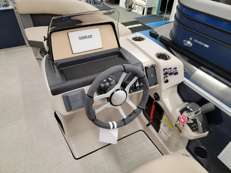 Slide: The Image of 2024 Harris Cruiser 210 boat dashboard with steering wheel and Simrad display. - 13