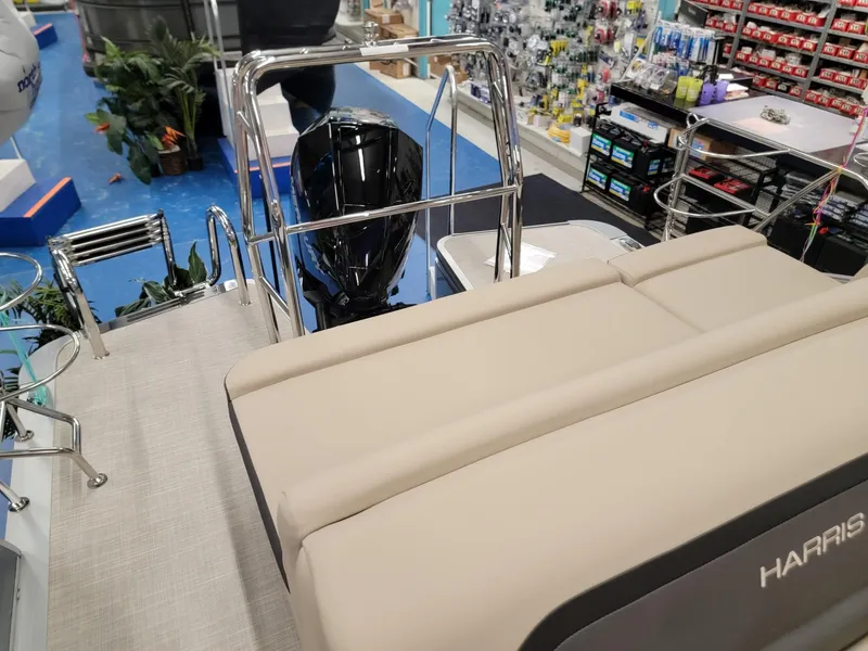 Slide: The Image of 2024 Harris Cruiser 210 boat interior with beige seating and outboard motor. - 20