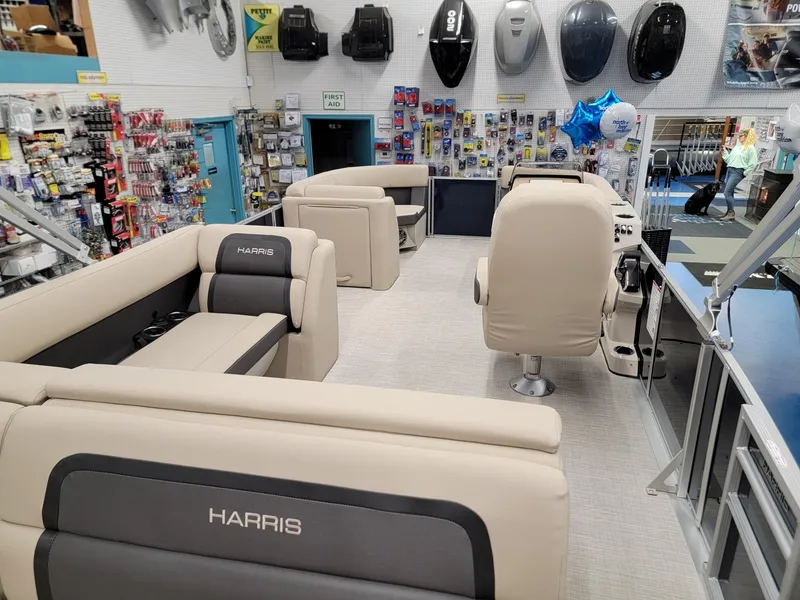 Slide: The Image of 2024 Harris Cruiser 210 boat interior in a showroom with accessories on display. - 23