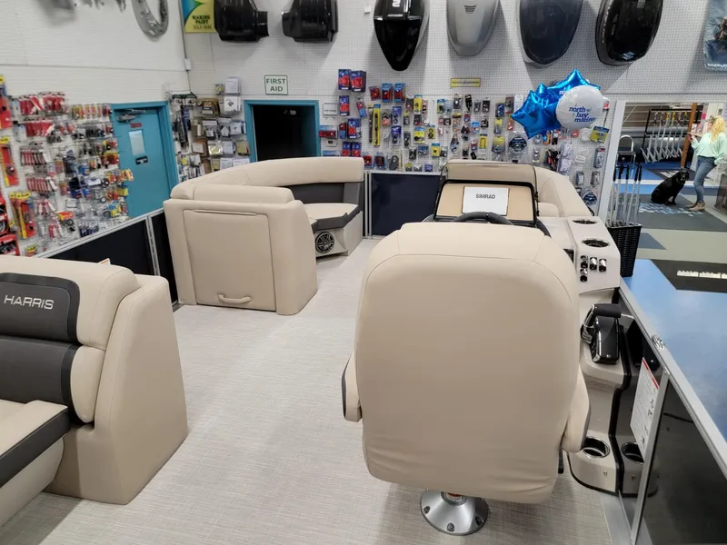 Slide: The Image of 2024 Harris Cruiser 210 boat interior with beige seating in a showroom. - 25