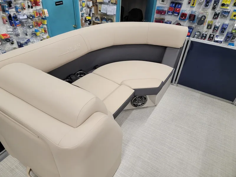 Slide: The Image of 2024 Harris Cruiser 210 boat interior with beige seating and speaker system. - 28