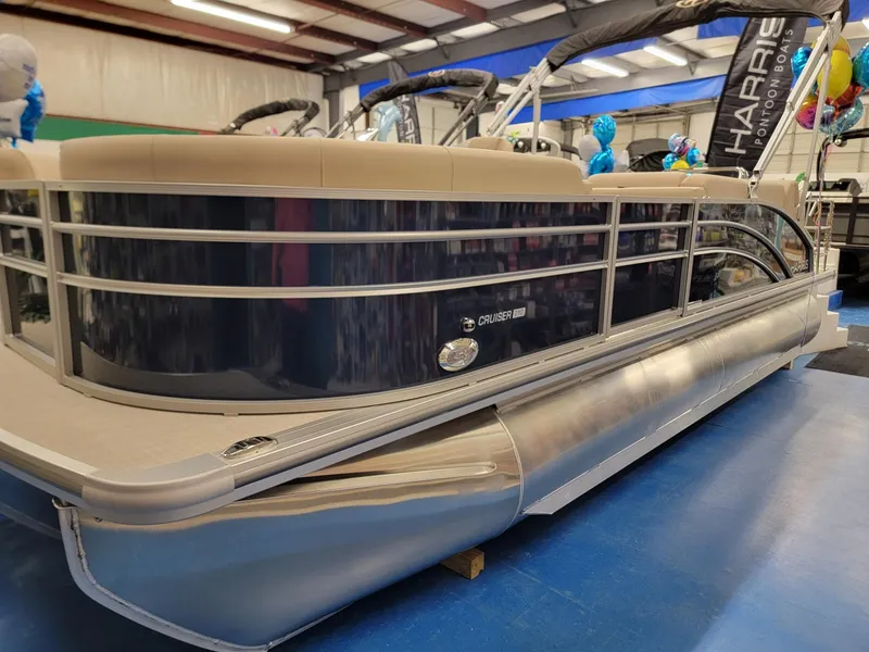 Slide: The Image of 2024 Harris Cruiser 210 pontoon boat on display in showroom. - 3