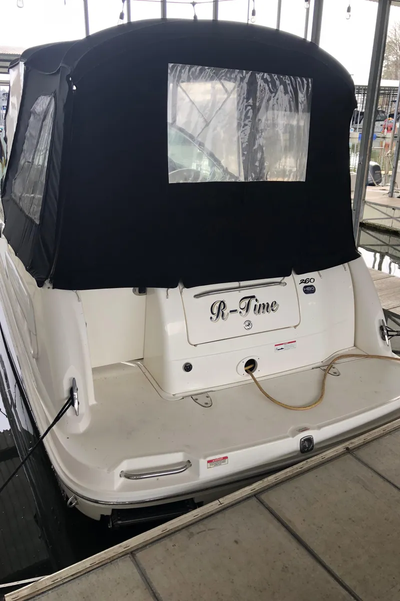 Slide: The Image of 2007 Sea Ray 260 Sundancer boat docked with black canvas cover. - 2