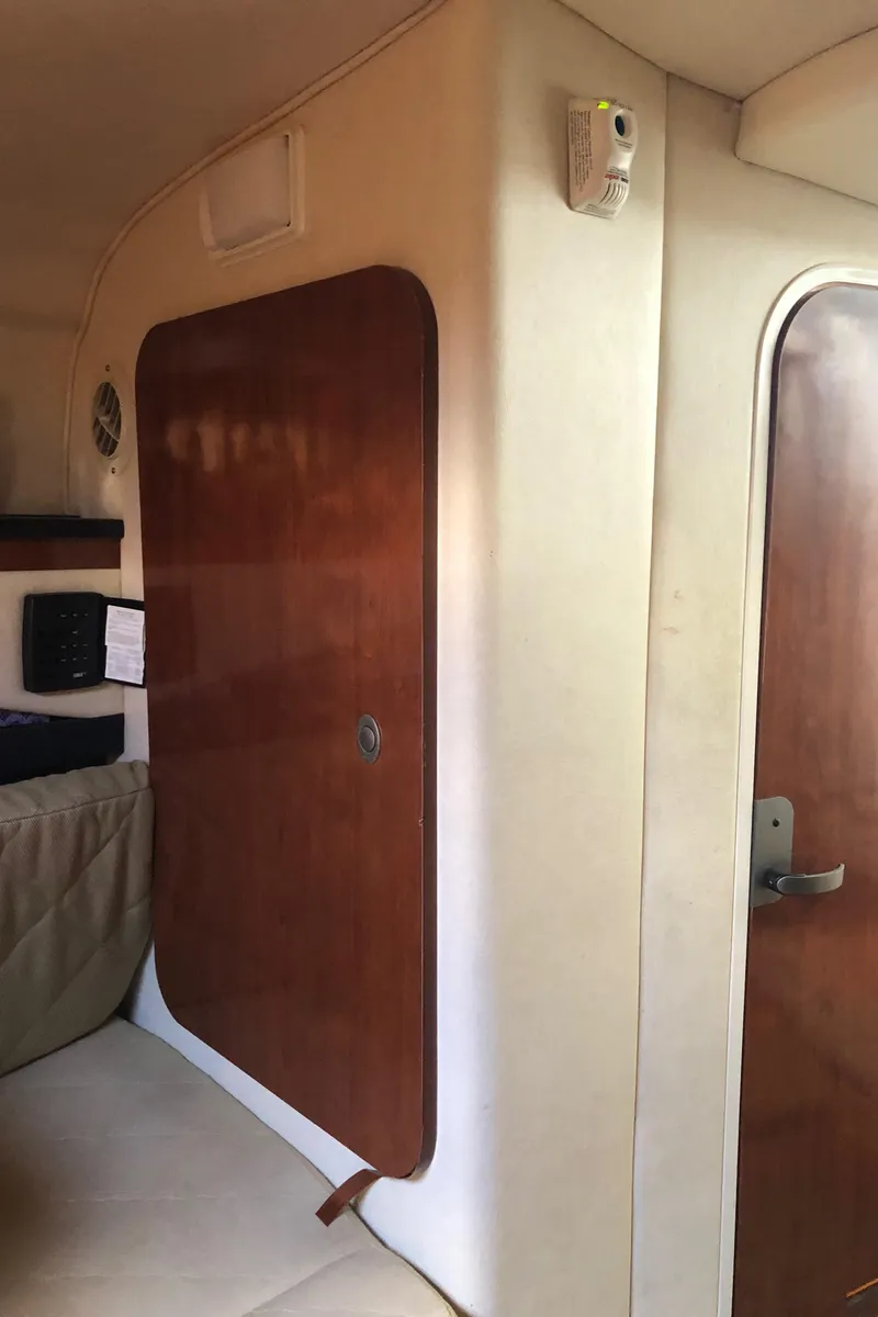 Slide: The Image of Interior cabin of a 2007 Sea Ray 260 Sundancer boat with wooden door and beige walls. - 29