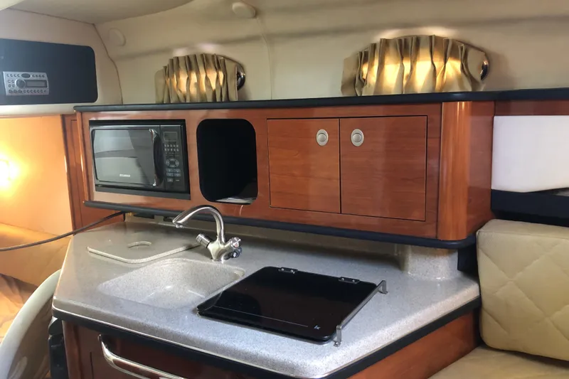 Slide: The Image of 2007 Sea Ray 260 Sundancer galley with microwave, sink, and storage cabinets. - 31