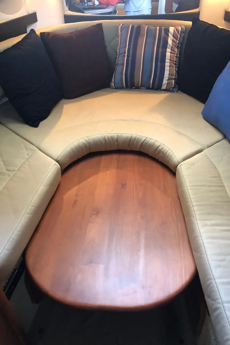 Slide: The Image of 2007 Sea Ray 260 Sundancer cabin with cushioned seating and wooden table. - 32