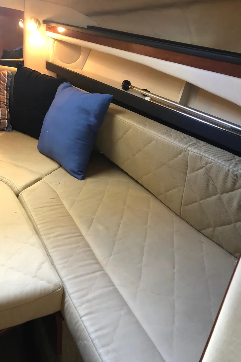 Slide: The Image of Interior seating of 2007 Sea Ray 260 Sundancer with beige upholstery and blue pillow. - 33