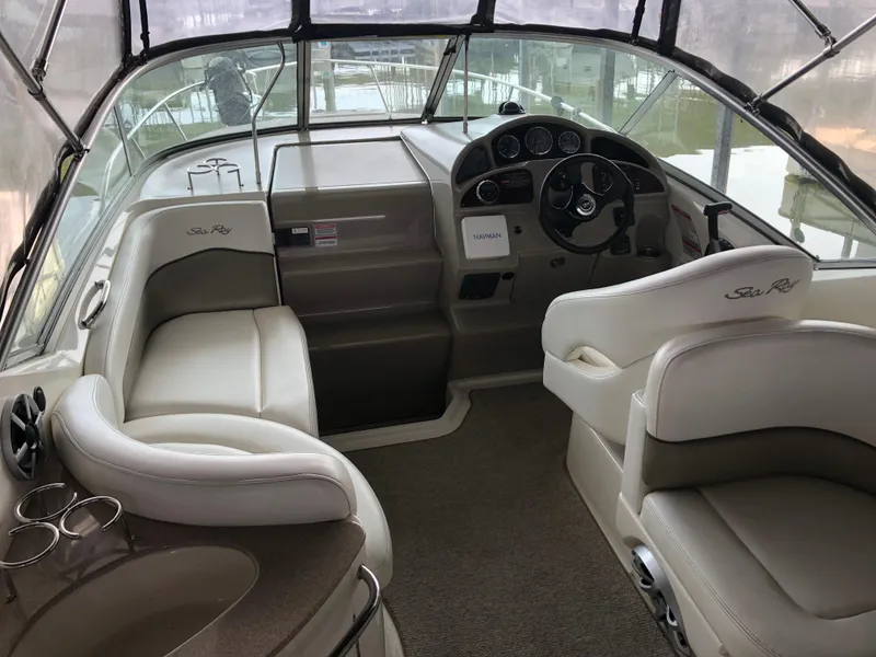 Slide: The Image of Interior of a 2007 Sea Ray 260 Sundancer boat with beige seating and steering console. - 9