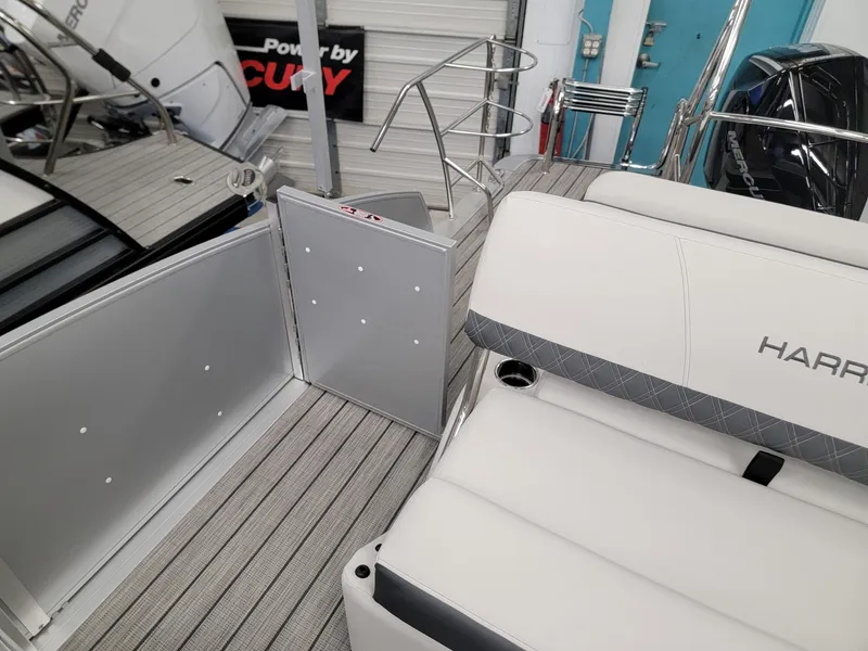 Slide: The Image of 2024 Harris Sunliner 210 boat interior with white seating and open gate. - 16