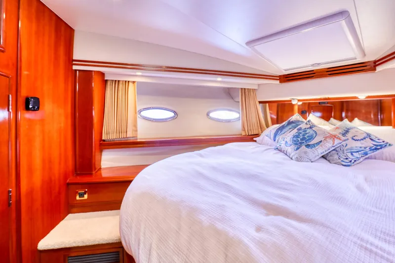 Slide: The Image of Luxurious bedroom interior of 2005 Carver 560 Voyager yacht with plush bedding and porthole windows. - 12