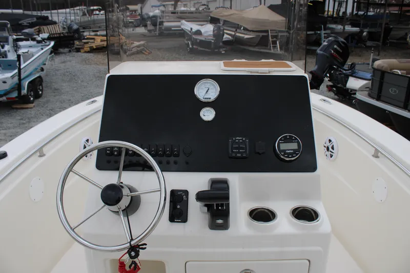 Slide: The Image of 2024 Bulls Bay 200 Center Console boat dashboard with steering wheel and controls. - 6