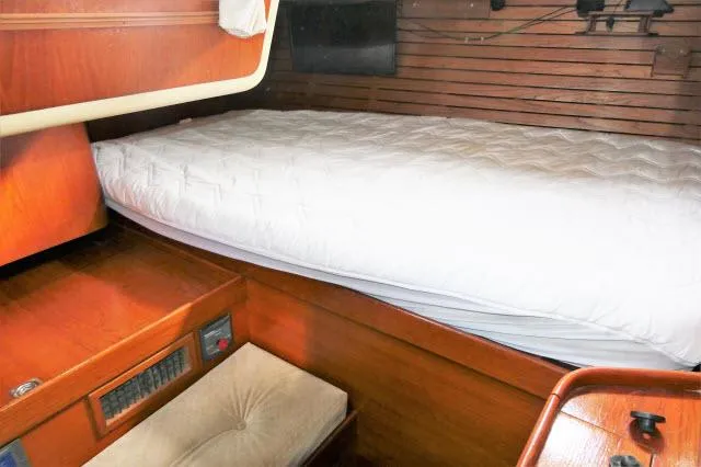 Slide: The Image of Cozy cabin interior of 1984 Nautor Swan 391 sailboat with wooden furnishings and a comfortable bed. - 29