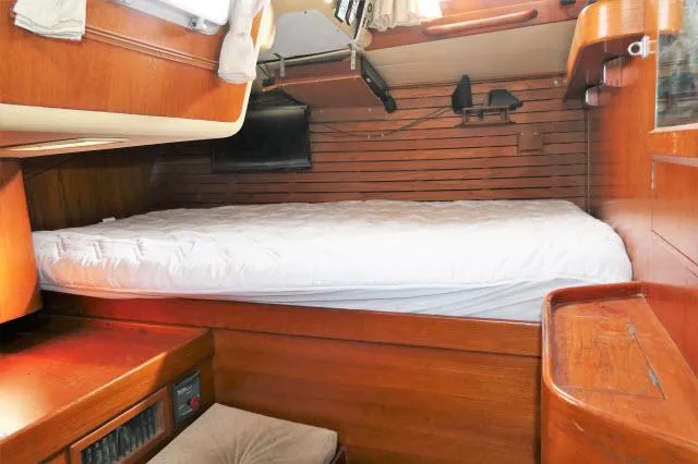Slide: The Image of Cozy cabin interior of 1984 Nautor Swan 391 sailboat with wooden furnishings and a comfortable bed. - 30