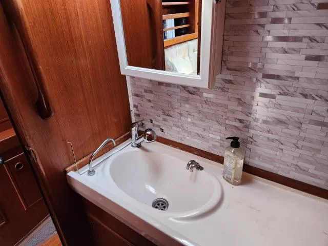 Slide: The Image of Bathroom sink area in a 1984 Nautor Swan 391 yacht with wooden cabinetry and tiled backsplash. - 36