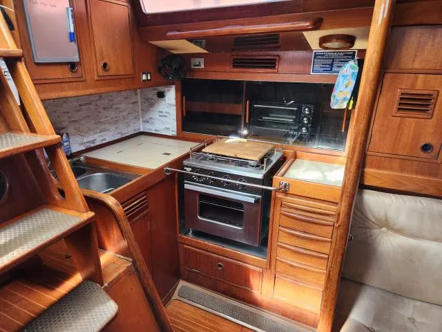 Slide: The Image of 1984 Nautor Swan 391 yacht kitchen with wooden cabinetry and modern appliances. - 7