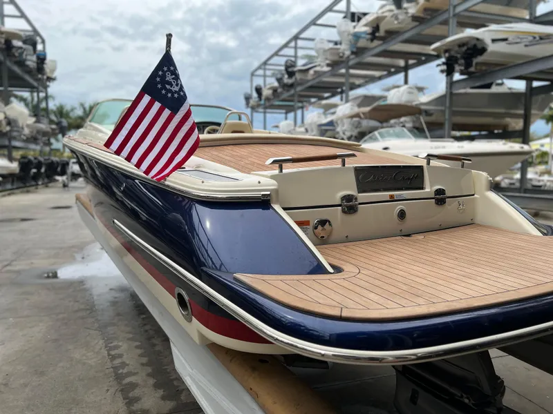 Slide: The Image of 2022 Chris-Craft Launch 27 boat with American flag in marina storage. - 10