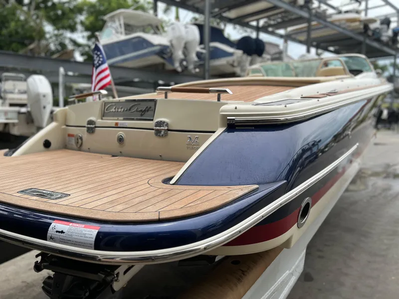 Slide: The Image of 2022 Chris-Craft Launch 27 boat with teak deck and American flag in marina. - 11