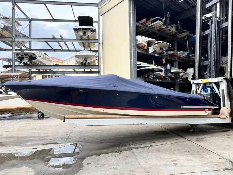 Slide: The Image of 2022 Chris-Craft Launch 27 boat in storage, covered with a blue tarp. - 14