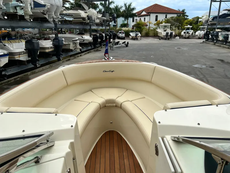 Slide: The Image of 2022 Chris-Craft Launch 27 boat with luxurious seating and wooden deck in a marina. - 18