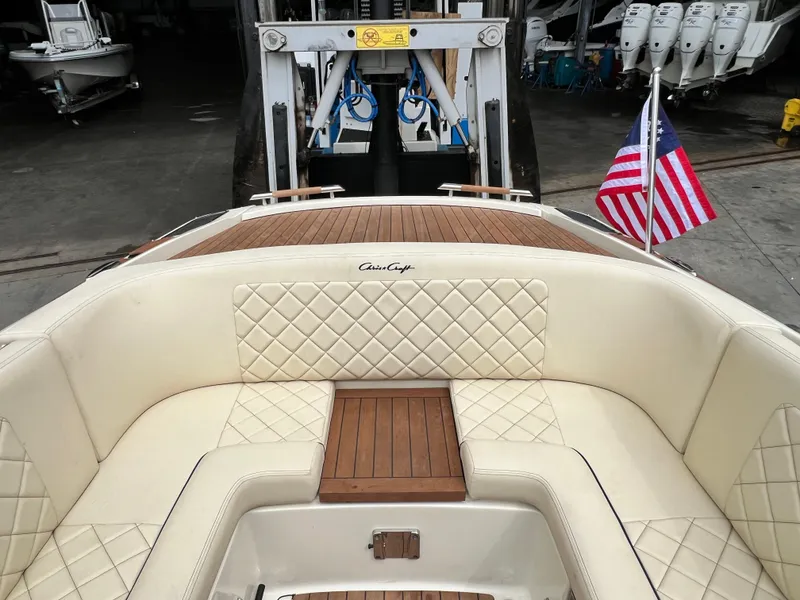 Slide: The Image of 2022 Chris-Craft Launch 27 boat with American flag, docked in a marina. - 21