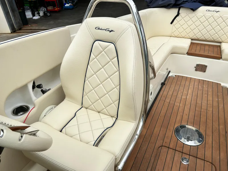 Slide: The Image of 2022 Chris-Craft Launch 27 boat interior with cream leather seats and teak flooring. - 26