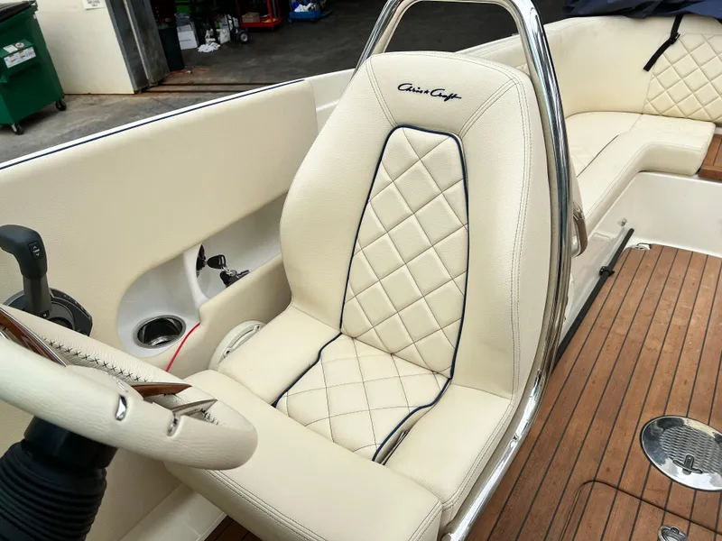 Slide: The Image of 2022 Chris-Craft Launch 27 boat interior with beige diamond-stitched seats and wooden flooring. - 27
