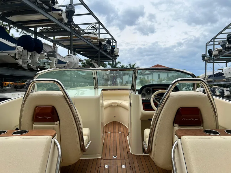 Slide: The Image of 2022 Chris-Craft Launch 27 boat interior with beige seats and wooden flooring. - 28