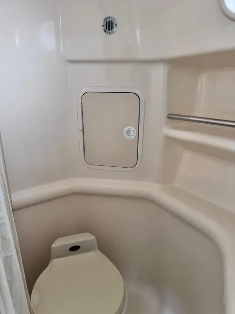Slide: The Image of 2000 Sea Ray 310 Sundancer bathroom with toilet and storage compartment. - 6