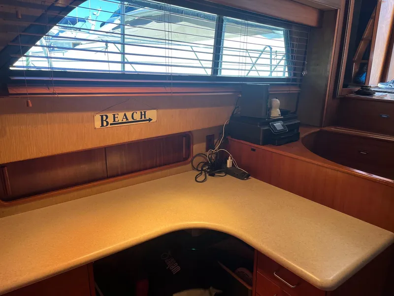 Slide: The Image of Interior workspace of 1986 Hatteras 70' Cockpit Motor Yacht with window and Beach sign. - 11