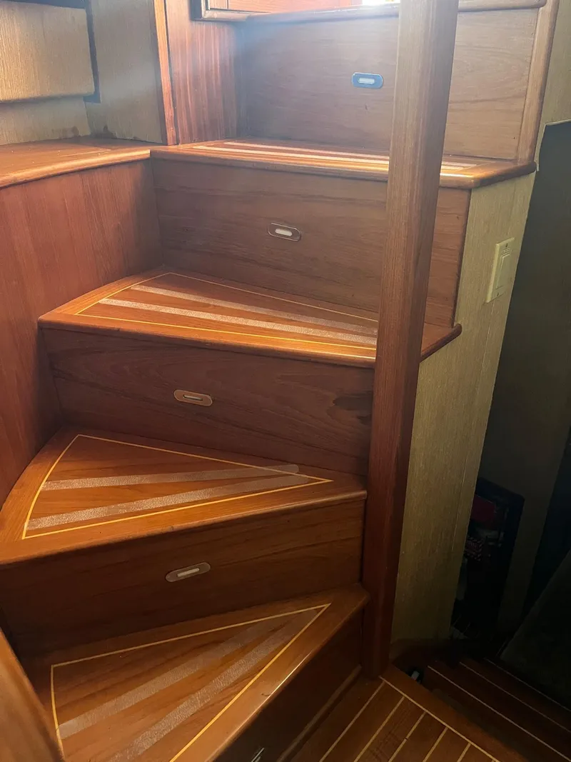 Slide: The Image of Wooden staircase inside a 1986 Hatteras 70' Cockpit Motor Yacht. - 12